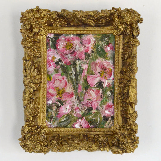 Decorative gold frame with a floral painting on a white background