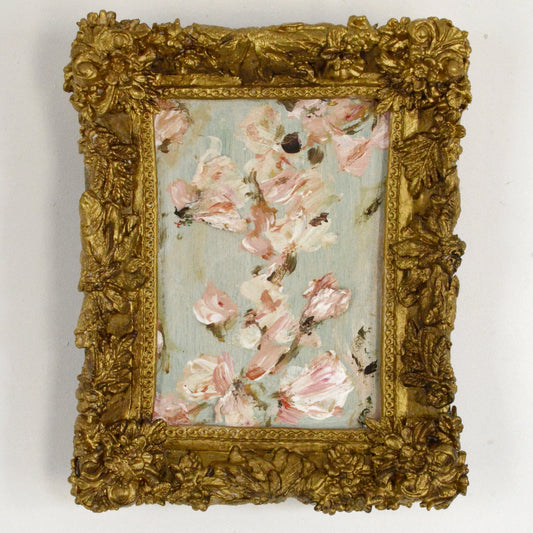 Decorative gold frame with a floral painting on a white background