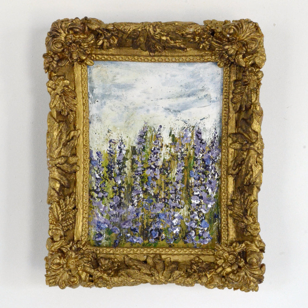 Decorative gold frame with a painting of flowers on a white background