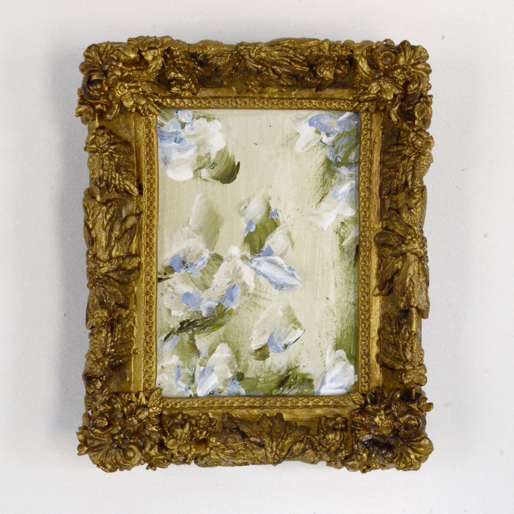 Decorative gold frame with a floral painting on a white background