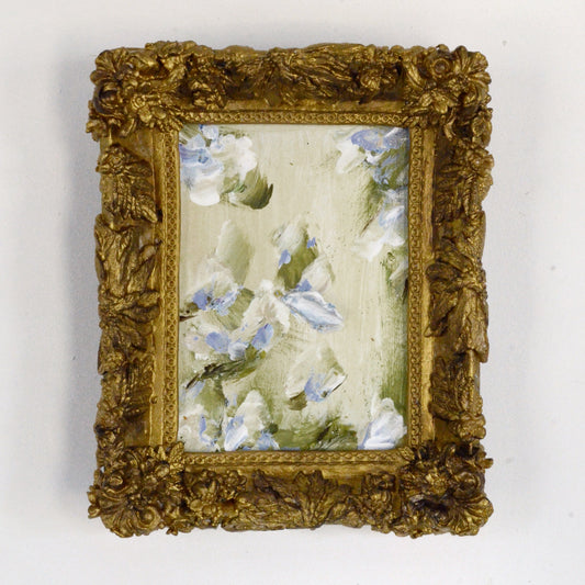 Decorative gold frame with a floral painting on a white background