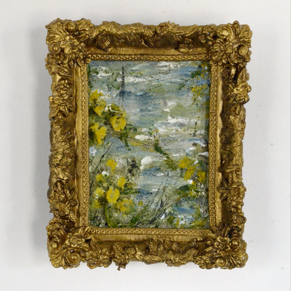 Framed painting with a gold frame on a white wall