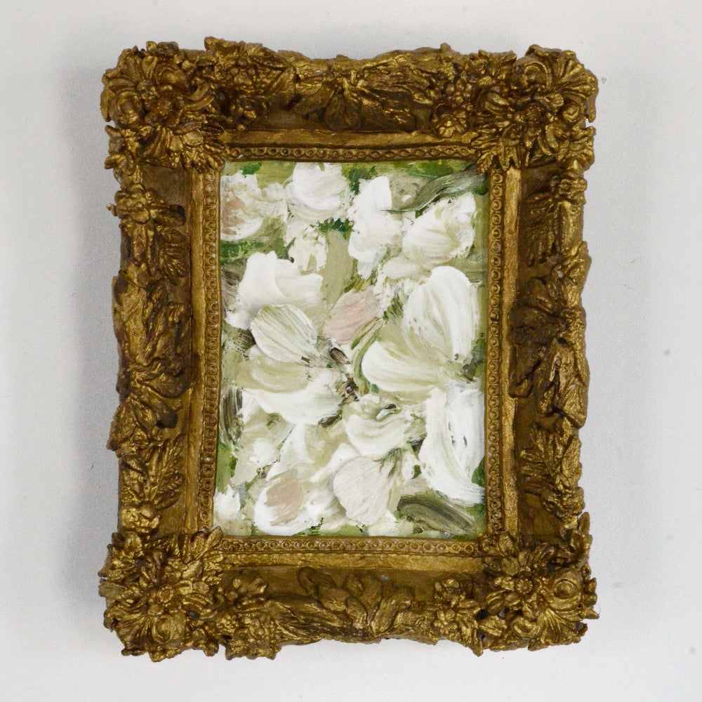 Decorative gold frame with a floral painting on a white background