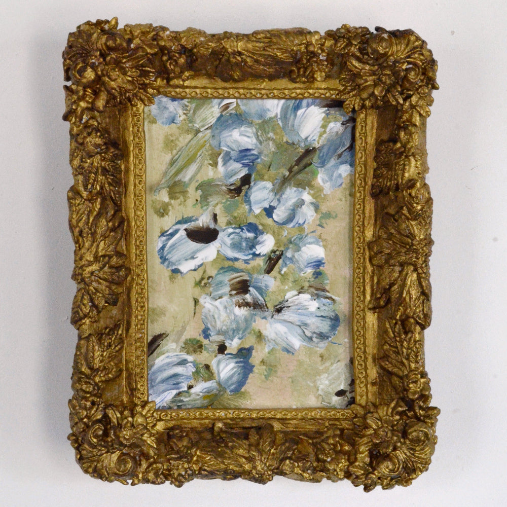 Decorative painting with blue flowers and a gold frame on a white background