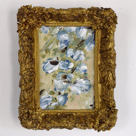 Decorative painting with blue flowers and a gold frame on a white background