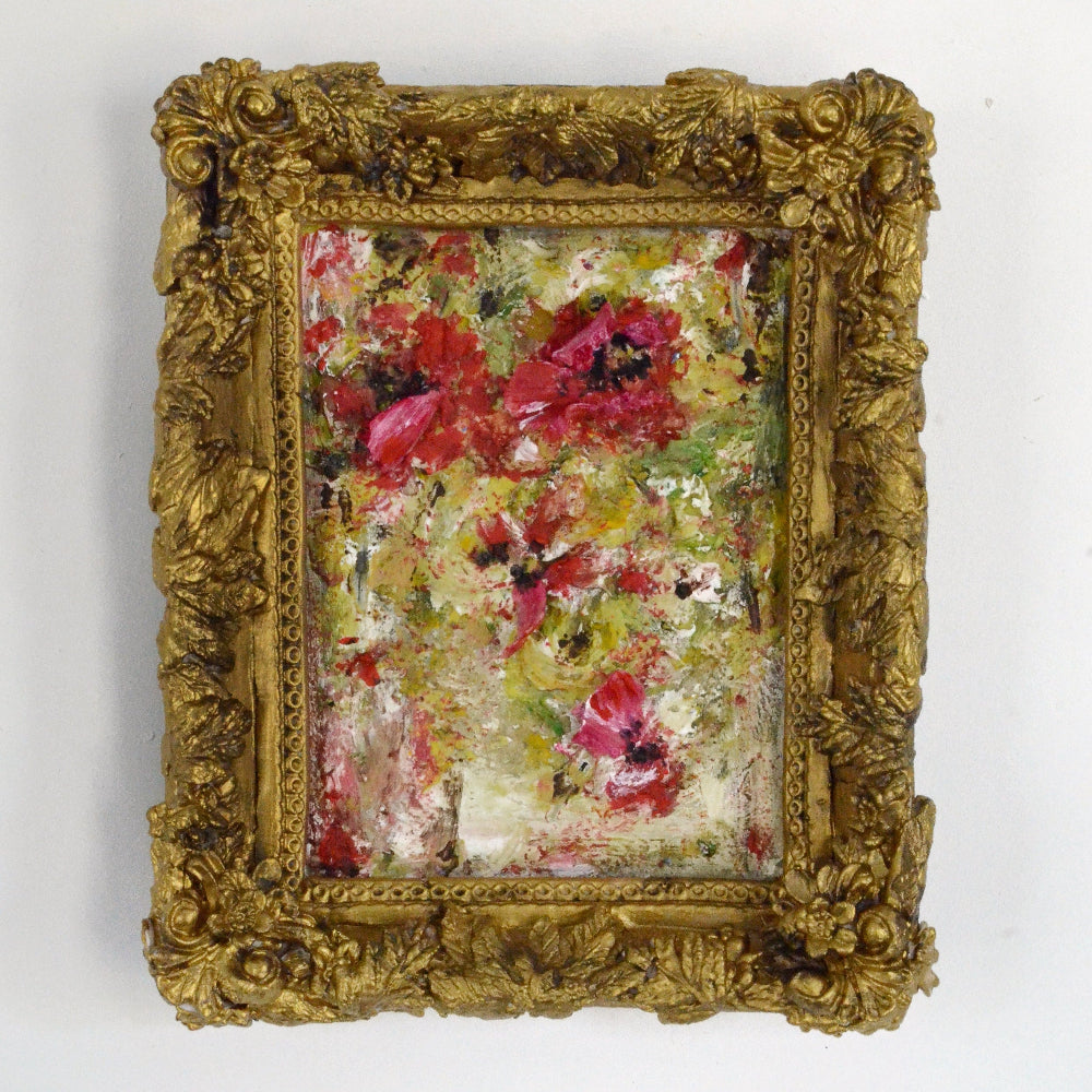 Floral painting in a gold frame on a white background