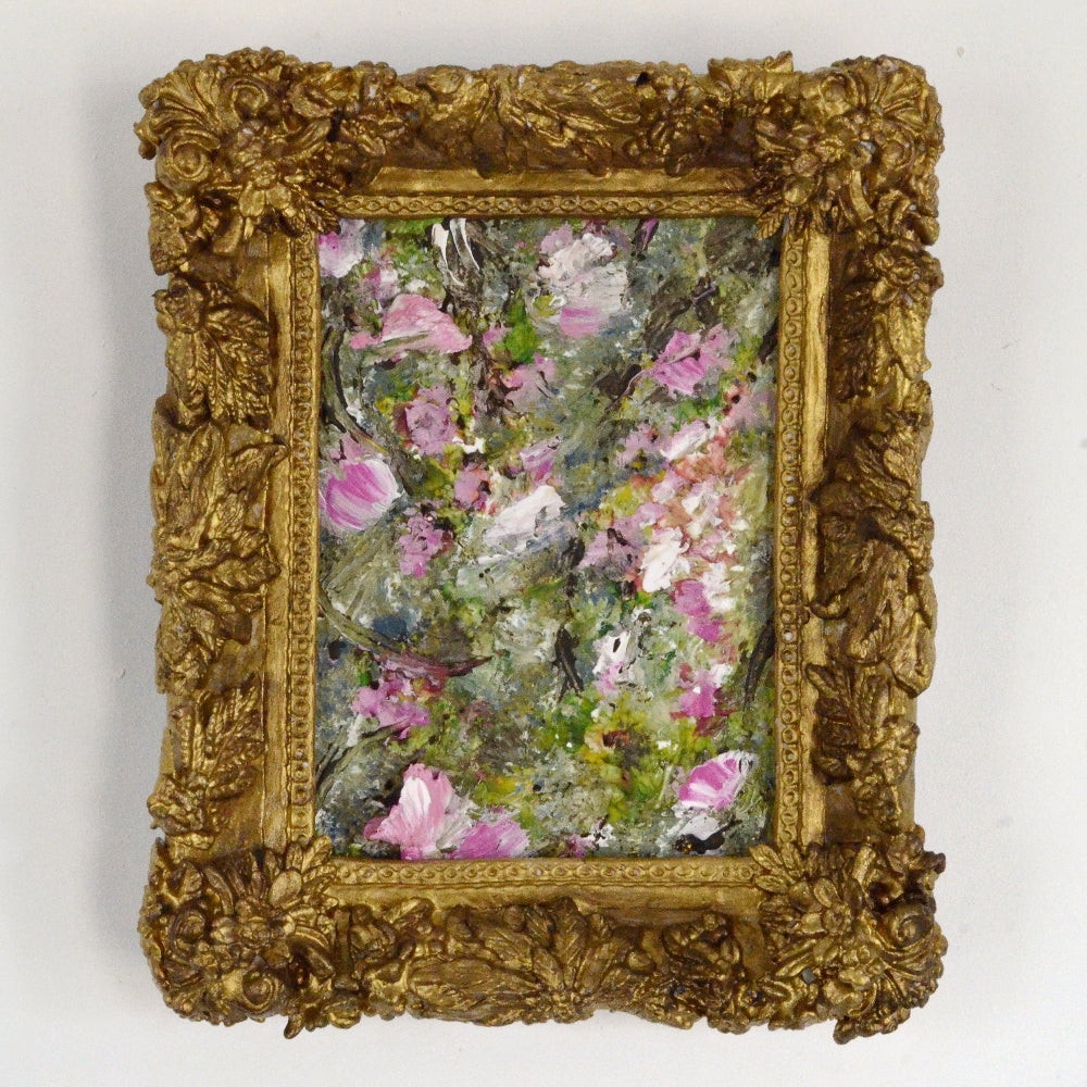 Small floral painting in a decorative gold frame on a white background