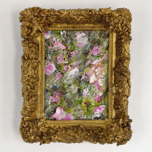 Small floral painting in a decorative gold frame on a white background