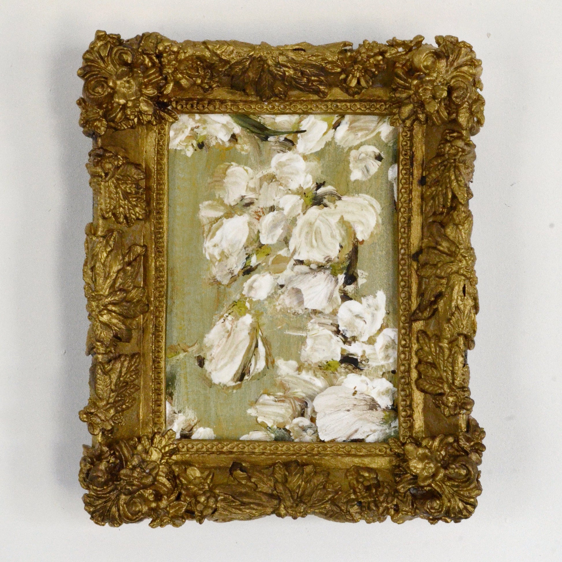 Decorative gold frame with a floral painting on a white background