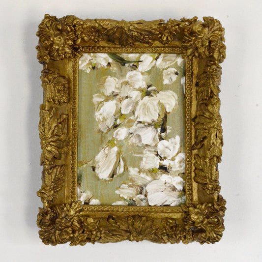 Decorative gold frame with a floral painting on a white background