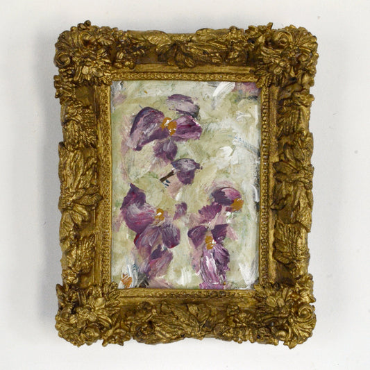 Decorative gold frame with a floral painting on a white background